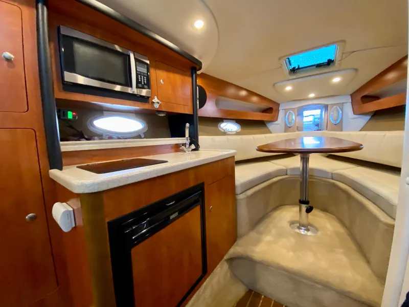 Slide: The Image of 2008 Rinker 280 Express Cruiser interior with kitchenette and seating area. - 19