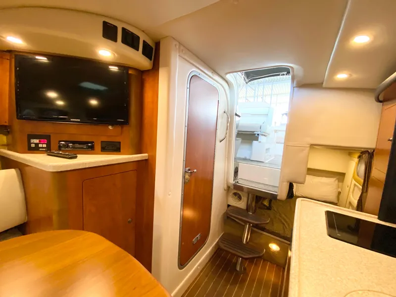Slide: The Image of Interior of 2008 Rinker 280 Express Cruiser with modern amenities and wood finishes. - 20