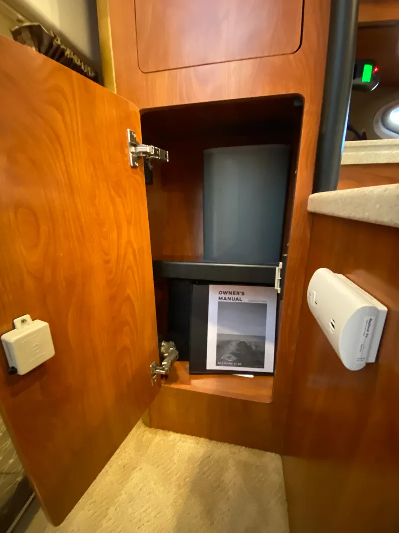 Slide: The Image of Open cabinet in 2008 Rinker 280 Express Cruiser with owner's manual inside. - 26