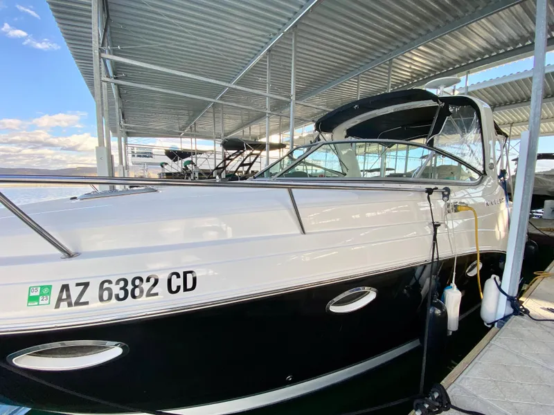Slide: The Image of 2008 Rinker 280 Express Cruiser docked under a metal canopy. - 3