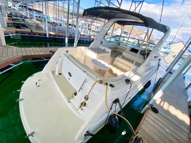 Slide: The Image of 2008 Rinker 280 Express Cruiser docked in a marina, featuring spacious seating and canopy. - 37