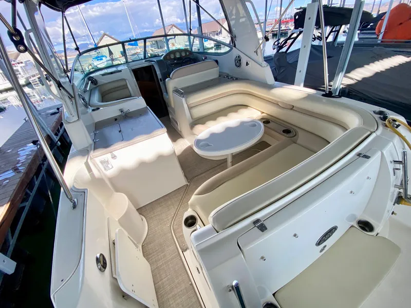Slide: The Image of 2008 Rinker 280 Express Cruiser interior with seating and table, docked at marina. - 38