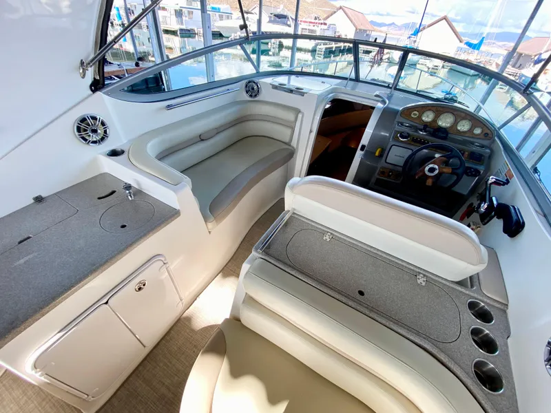 Slide: The Image of 2008 Rinker 280 Express Cruiser interior with helm, seating, and dashboard at marina. - 39