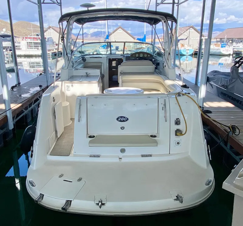 Slide: The Image of 2008 Rinker 280 Express Cruiser docked at marina, rear view showing spacious deck. - 43