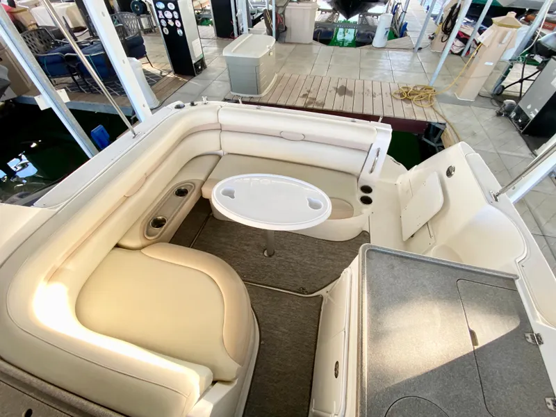 Slide: The Image of 2008 Rinker 280 Express Cruiser interior with seating and table in a marina setting. - 7