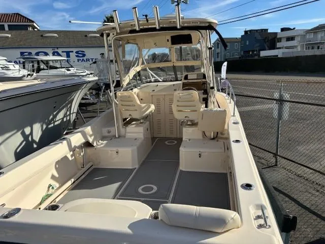 Slide: The Image of 2018 Grady-White 228 Seafarer boat interior at marina, featuring seating and helm. - 15