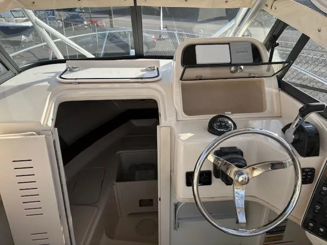 Slide: The Image of 2018 Grady-White 228 Seafarer boat interior with steering wheel and cabin entrance. - 19