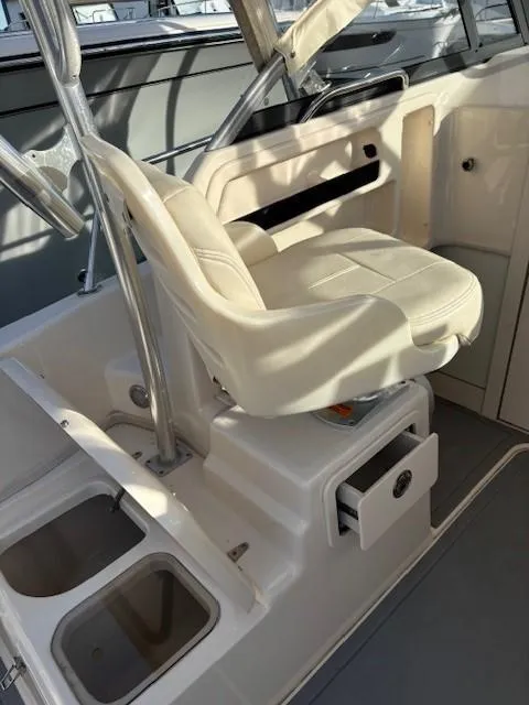 Slide: The Image of 2018 Grady-White 228 Seafarer boat interior with white captain's chair and storage compartments. - 25