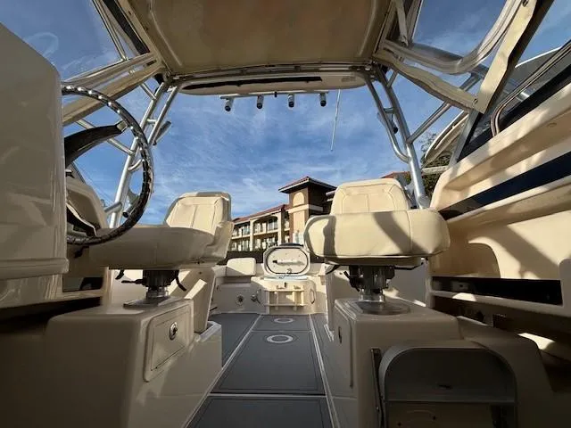 Slide: The Image of 2018 Grady-White 228 Seafarer boat interior with helm and seating under clear sky. - 26