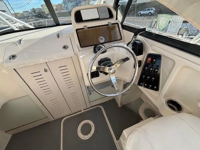 Slide: The Image of 2018 Grady-White 228 Seafarer boat interior with steering wheel and control panel. - 27