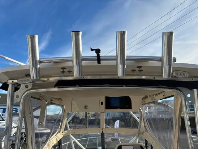 Slide: The Image of 2018 Grady-White 228 Seafarer boat with rod holders and clear canopy under a blue sky. - 36
