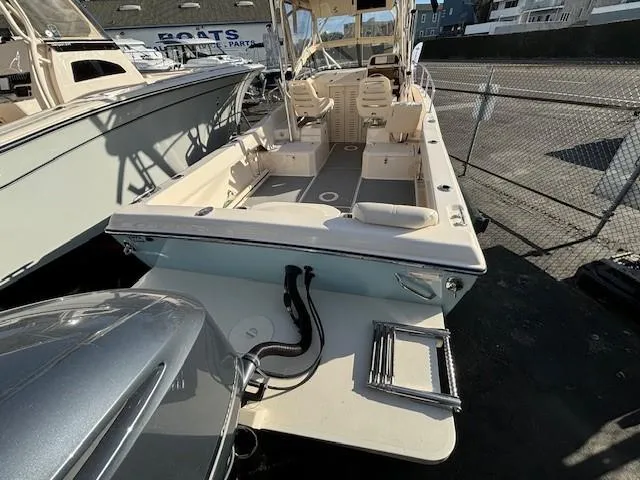 Slide: The Image of 2018 Grady-White 228 Seafarer boat, docked, showcasing spacious deck and seating. - 45