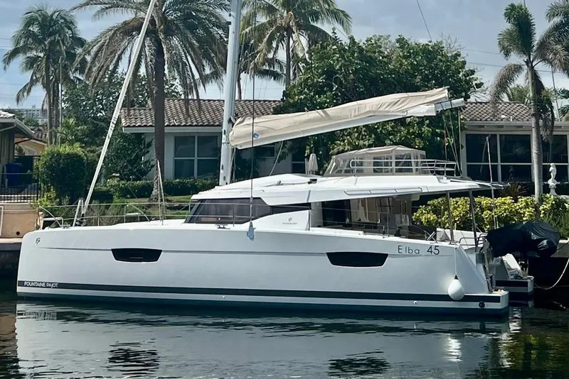 Slide: The Image of 2024 Fountaine Pajot Elba 45 Catamaran docked by palm trees. - 0