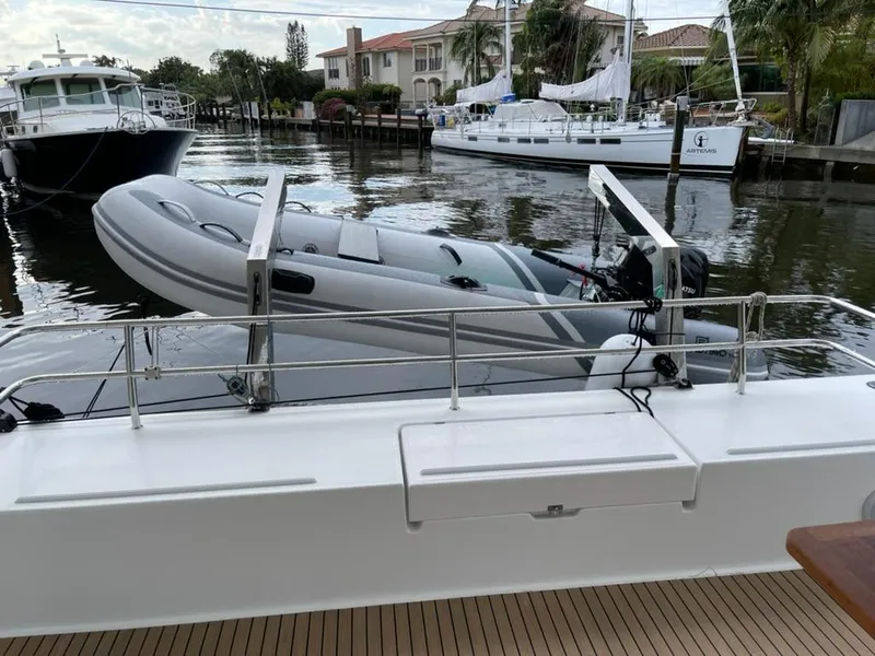 Slide: The Image of 2024 Fountaine Pajot Catamaran Elba 45 with dinghy on deck, docked in marina. - 3