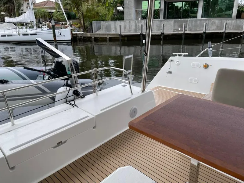Slide: The Image of 2024 Fountaine Pajot Catamaran Elba 45 deck with wooden table and waterfront view. - 4