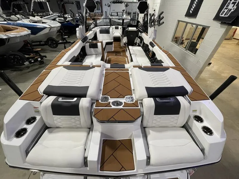 Slide: The Image of 2025 Malibu 26 LSV boat interior with luxurious seating and modern design in showroom. - 10