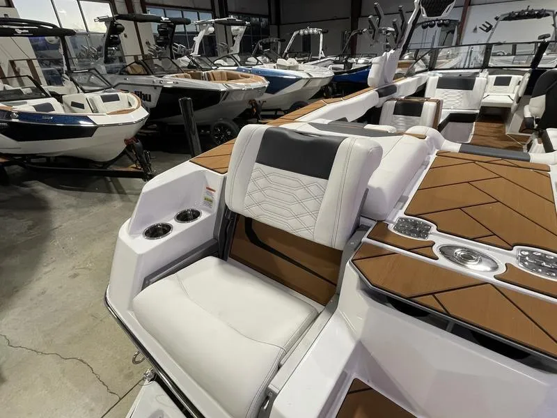 Slide: The Image of 2025 Malibu 26 LSV boat interior with luxurious seating and modern design in showroom. - 11