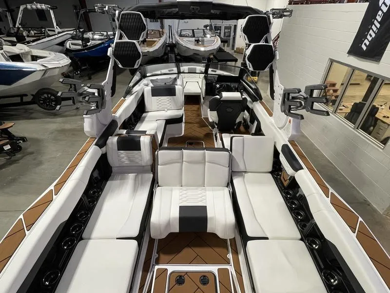 Slide: The Image of 2025 Malibu 26 LSV boat interior with white seating and advanced audio system. - 12