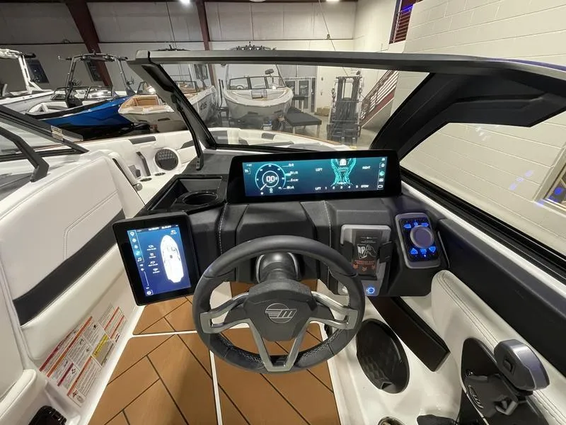 Slide: The Image of 2025 Malibu 26 LSV boat dashboard with modern digital displays and steering wheel. - 18