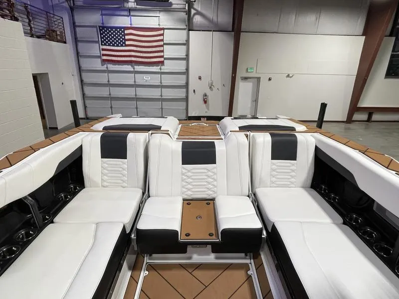 Slide: The Image of Interior of 2025 Malibu 26 LSV boat with white seating and American flag. - 24
