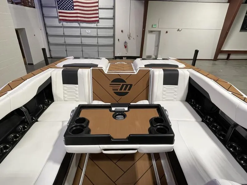 Slide: The Image of Interior of 2025 Malibu 26 LSV boat with luxurious seating and table setup. - 26