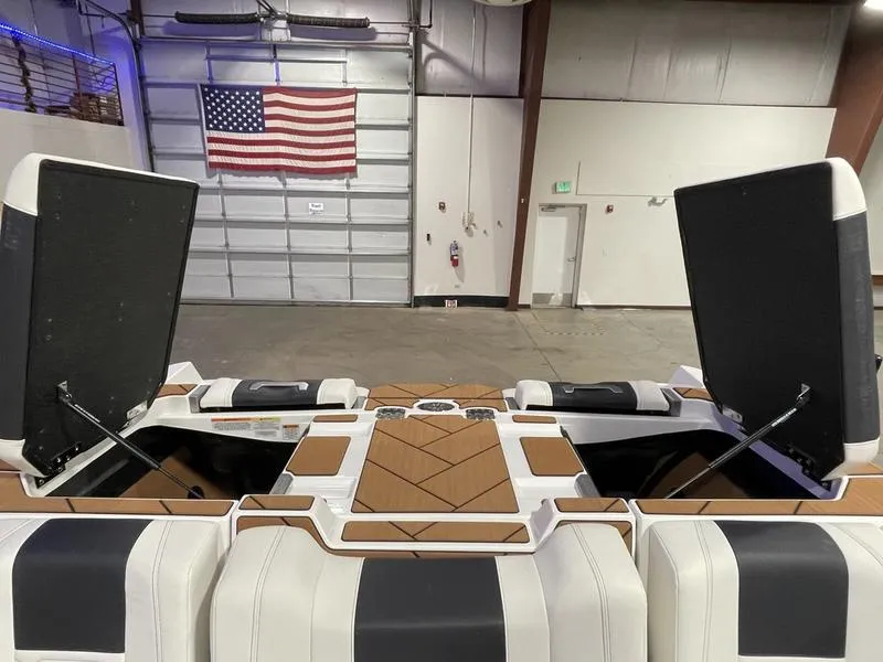 Slide: The Image of 2025 Malibu 26 LSV boat interior with open storage compartments in a warehouse setting. - 28