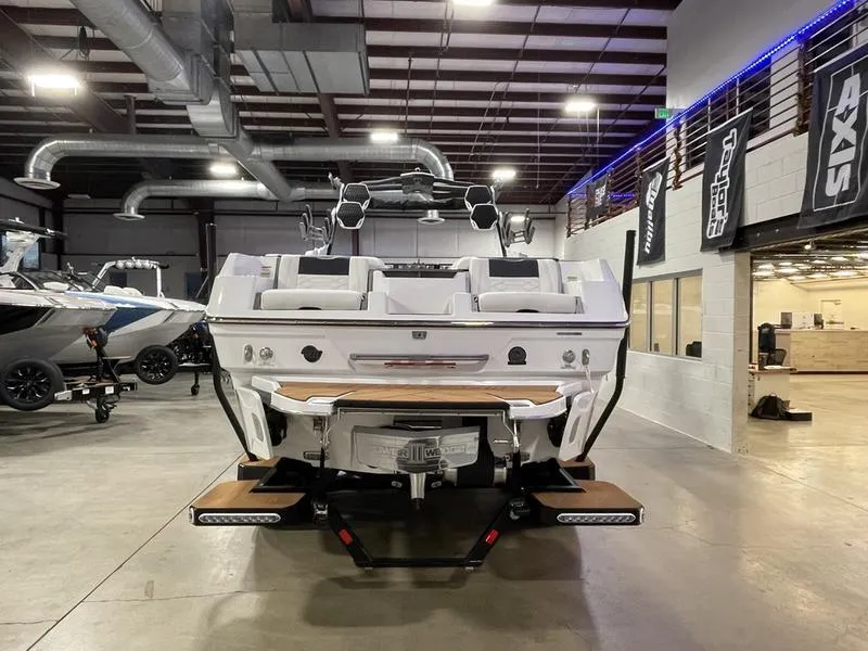 Slide: The Image of 2025 Malibu 26 LSV boat in showroom, rear view with modern design and features. - 9