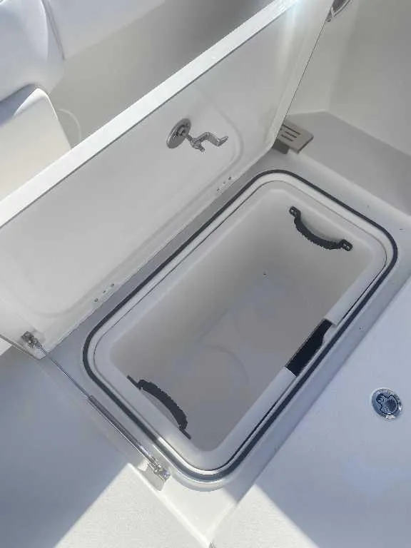Slide: The Image of Open storage compartment on 2025 Caymas 34 CT boat, featuring a sleek white interior. - 18