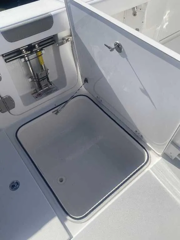 Slide: The Image of Open storage compartment on 2025 Caymas 34 CT boat, showcasing interior space and latch mechanism. - 19