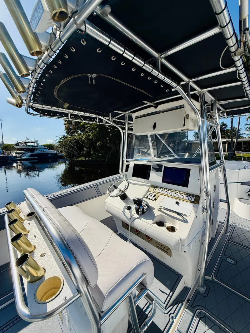 Slide: The Image of 2003 Fountain 38 TE boat cockpit with modern controls and seating, docked by the water. - 14