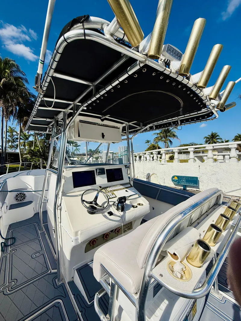 Slide: The Image of 2003 Fountain 38 TE boat with helm, rod holders, and palm trees in the background. - 15