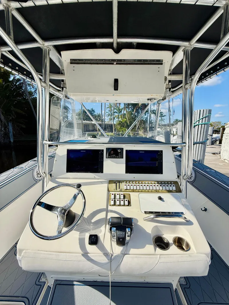 Slide: The Image of 2003 Fountain 38 TE boat cockpit with steering wheel, controls, and navigation screens. - 16