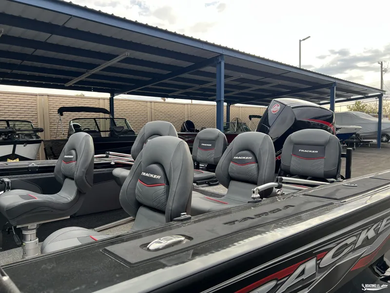 Slide: The Image of 2023 Tracker V-19 boat with gray seats under a covered area. - 3