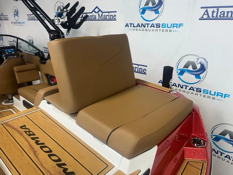 Slide: The Image of 2025 Moomba Max boat interior with tan seating and branded flooring at Atlanta's Surf Headquarters. - 13