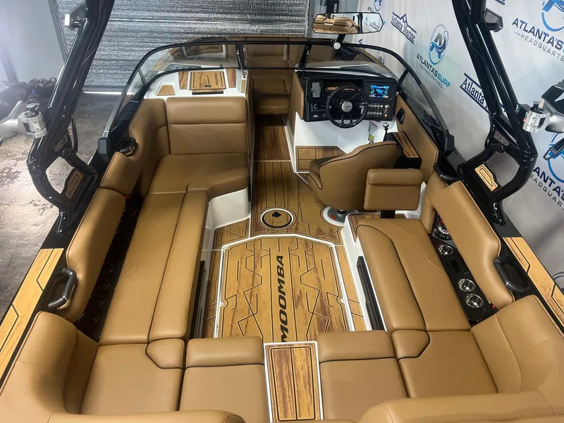 Slide: The Image of 2025 Moomba Max boat interior with tan seating and modern dashboard. - 14