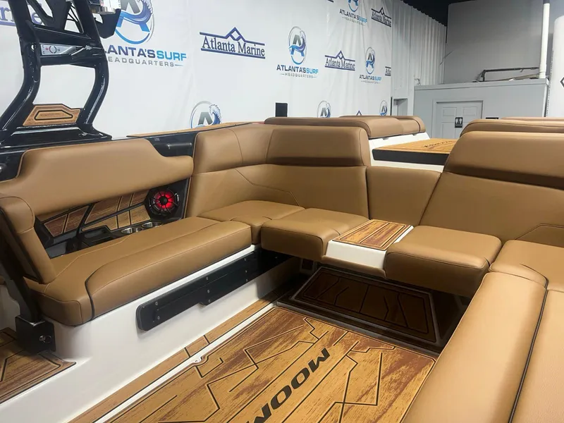 Slide: The Image of 2025 Moomba Max boat interior with tan leather seating and wood accents. - 16
