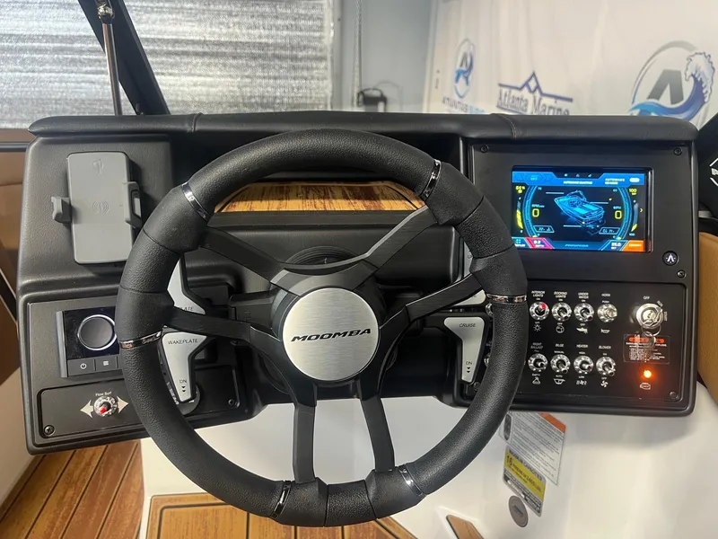 Slide: The Image of 2025 Moomba Max boat dashboard with steering wheel and digital display. - 21