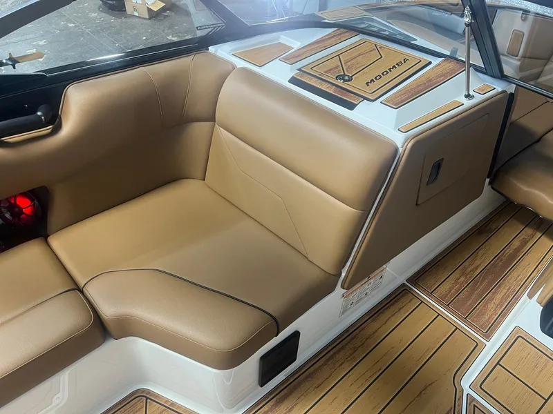 Slide: The Image of 2025 Moomba Max boat interior with tan seating and wood accents. - 22