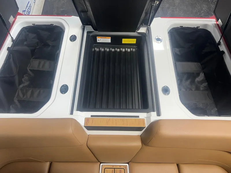 Slide: The Image of 2025 Moomba Max boat interior storage compartments with tan seating and black inserts. - 24