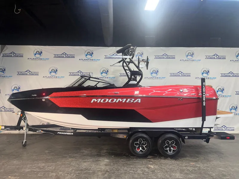 Slide: The Image of 2025 Moomba Max boat in showroom, red and black design, on trailer. - 3