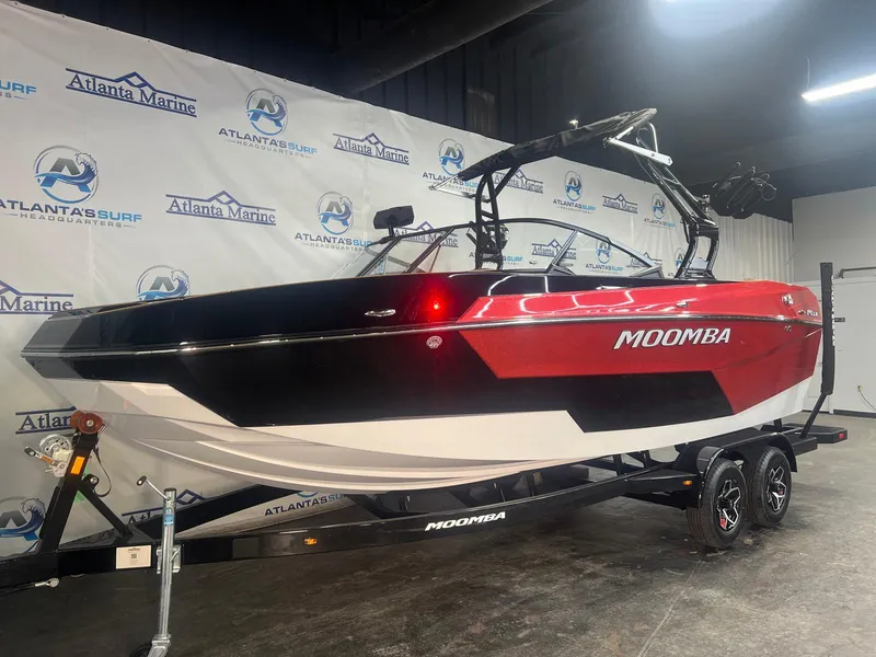 Slide: The Image of 2025 Moomba Max boat in showroom, red and black design, displayed at Atlanta Marine. - 4