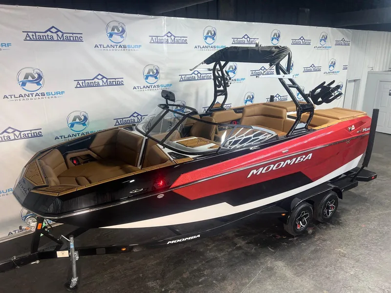 Slide: The Image of 2025 Moomba Max boat in showroom, red and black design, displayed at Atlanta Marine. - 5