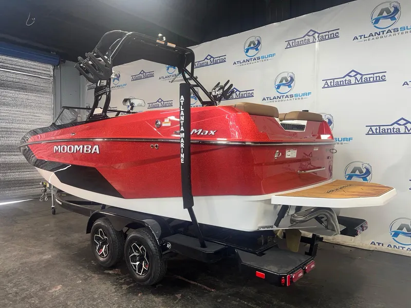 Slide: The Image of 2025 Moomba Max boat in showroom, red and white design, on trailer. - 6