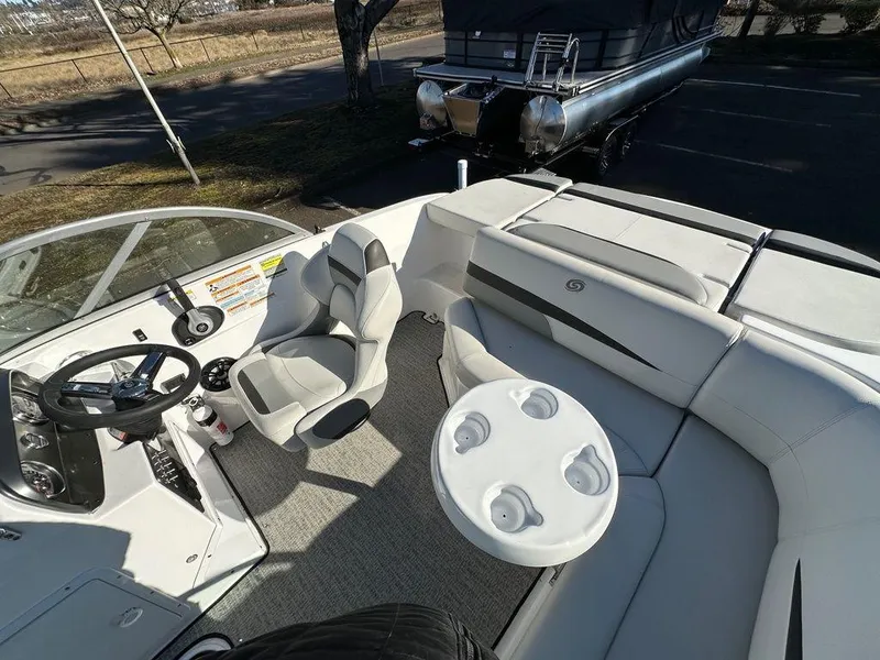 Slide: The Image of 2022 Hurricane SunDeck 187 IO boat interior with seating, steering wheel, and cup holders. - 8