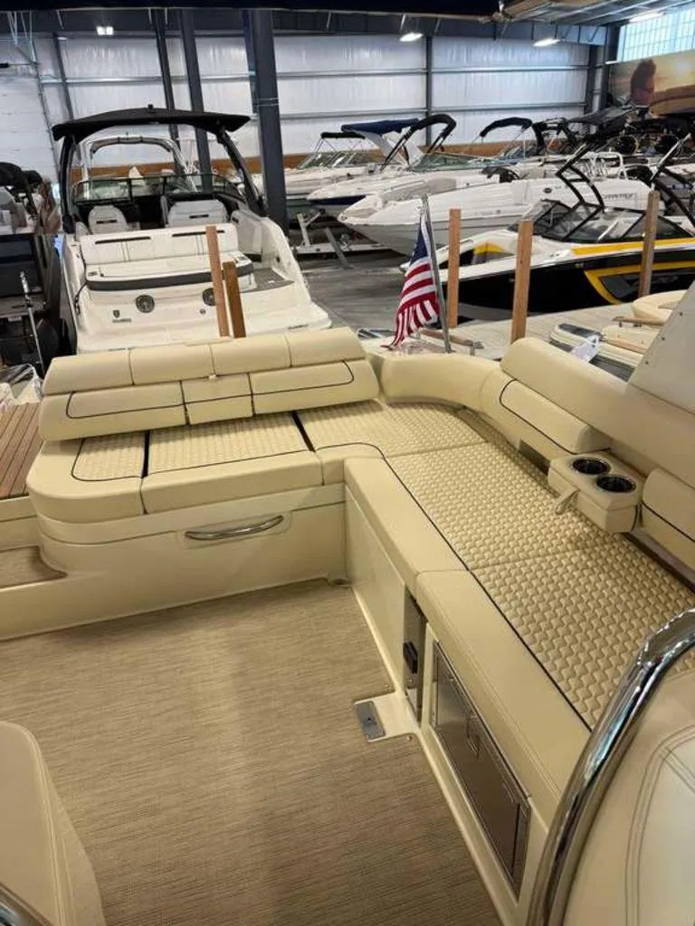 Slide: The Image of 2025 Chris-Craft Launch 31 GT interior with beige seating and American flag in showroom. - 6