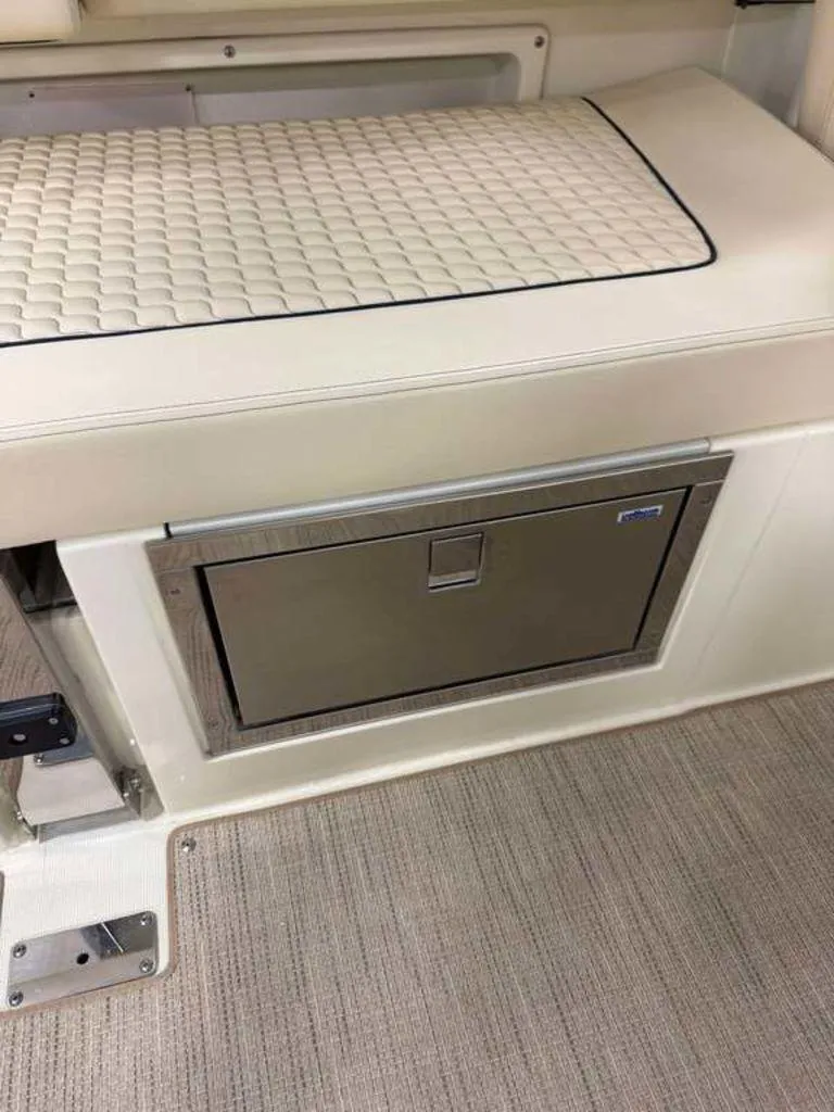 Slide: The Image of 2025 Chris-Craft Launch 31 GT interior with cushioned seating and built-in storage compartment. - 7