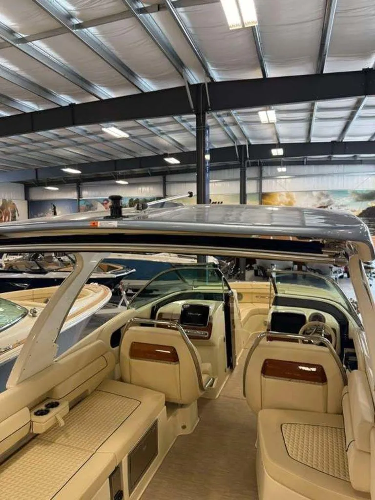 Slide: The Image of 2025 Chris-Craft Launch 31 GT boat interior in showroom, featuring luxurious seating and modern design. - 8