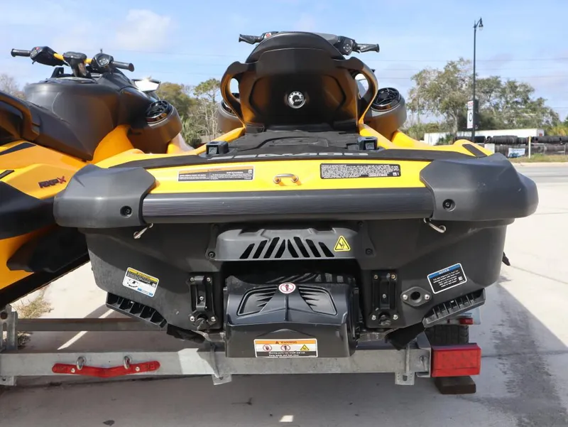 Slide: The Image of 2022 Sea-Doo GTR 230 jet ski, yellow and black, rear view on trailer. - 2