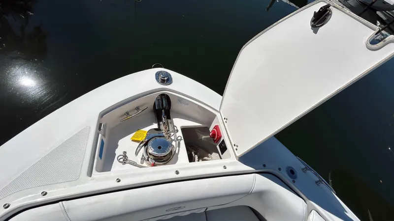 Slide: The Image of 2022 Regal LX6 boat anchor compartment with open hatch, showing storage and equipment. - 6