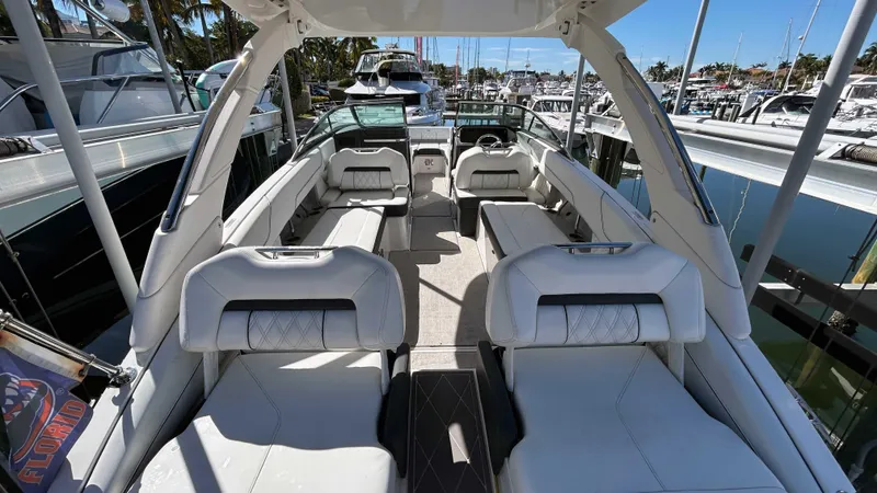 Slide: The Image of 2022 Regal LX6 boat interior with luxurious seating at a marina. - 8